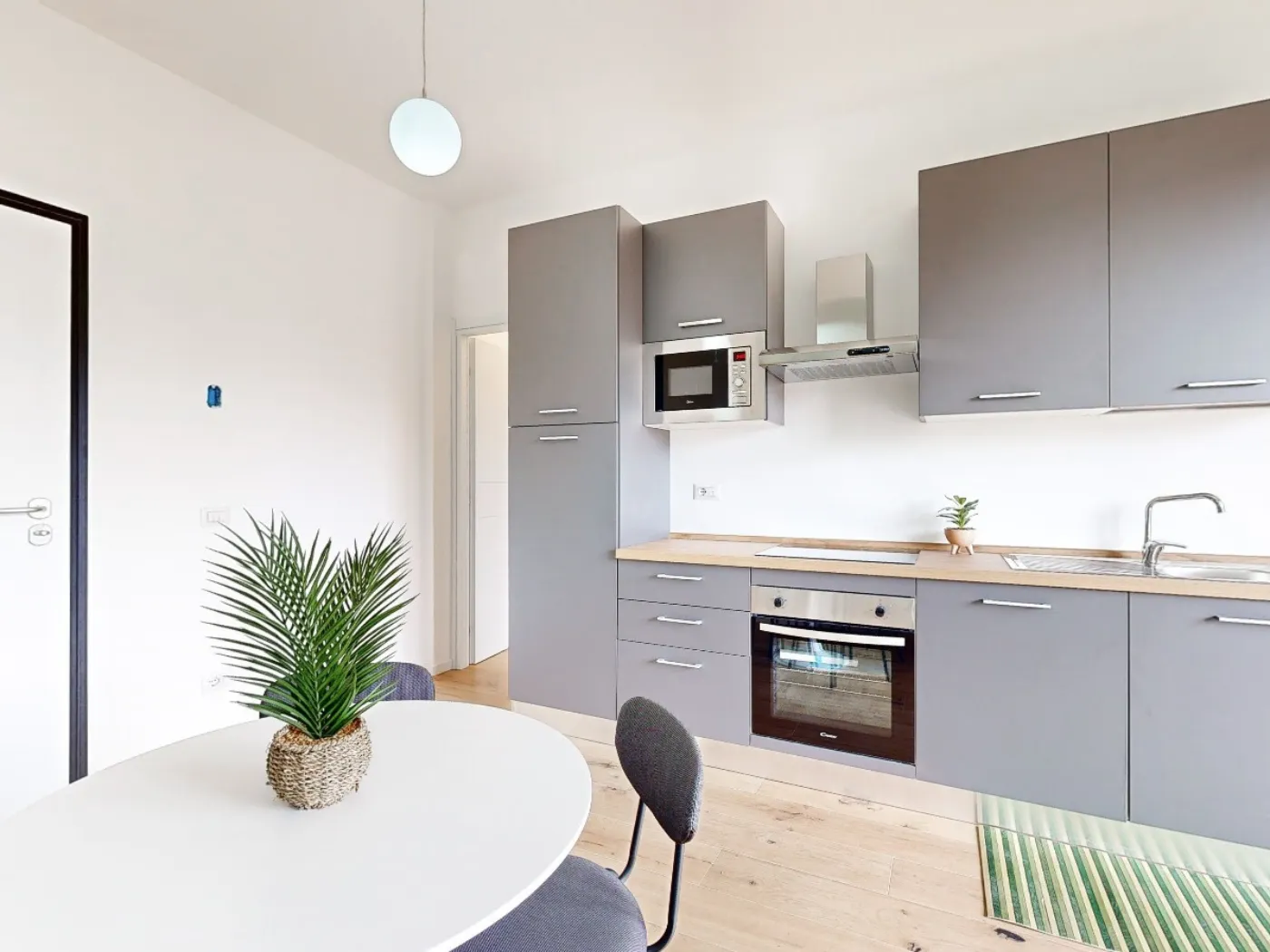 Bilocale open space con cucina grigio antracite e parquet rovere