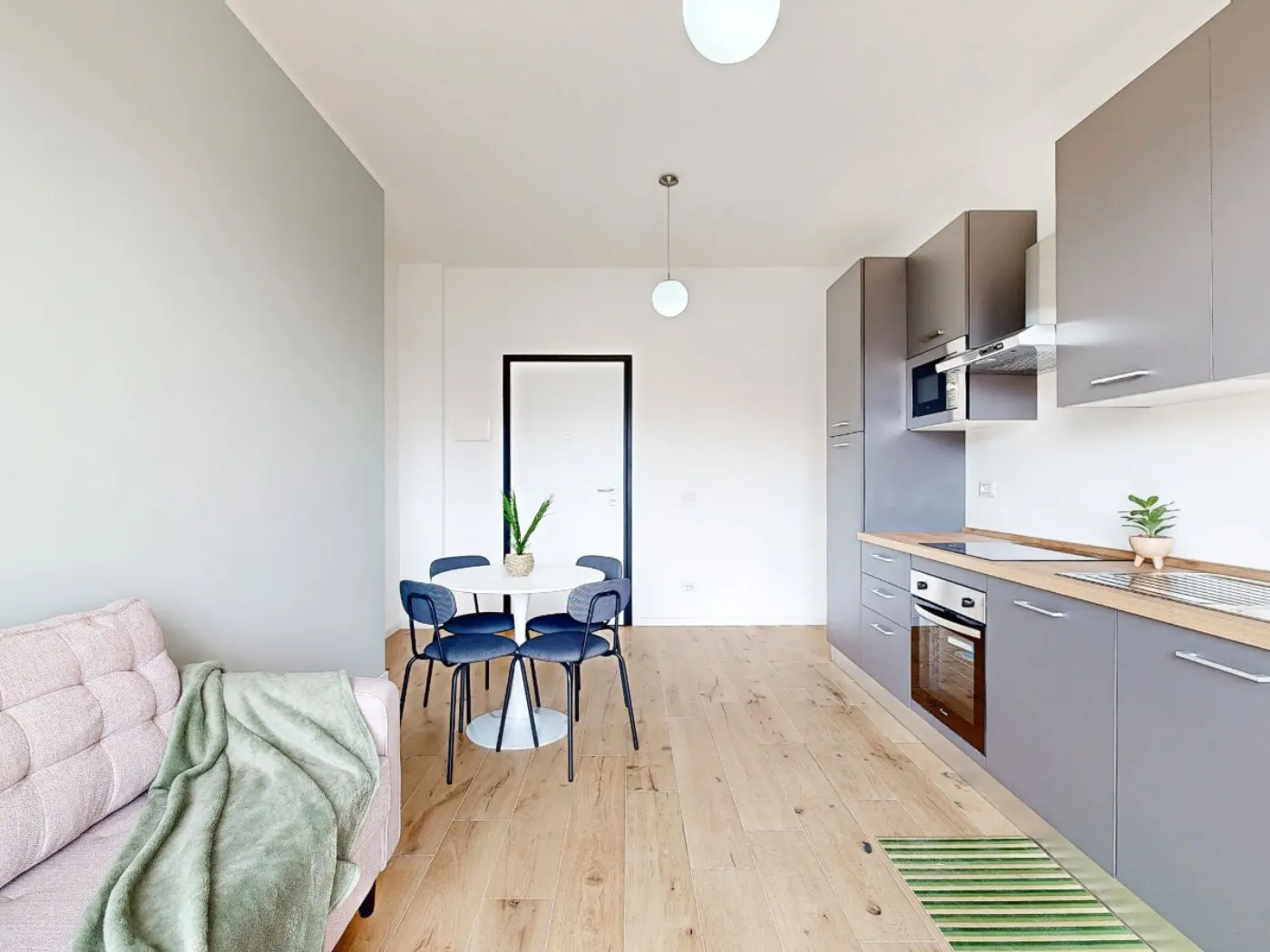 Bilocale open space con cucina grigio antracite e parquet rovere