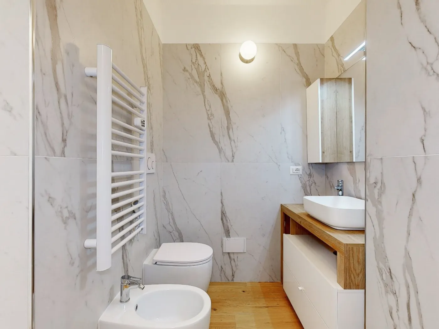 Bilocale open space con cucina grigio antracite e parquet rovere