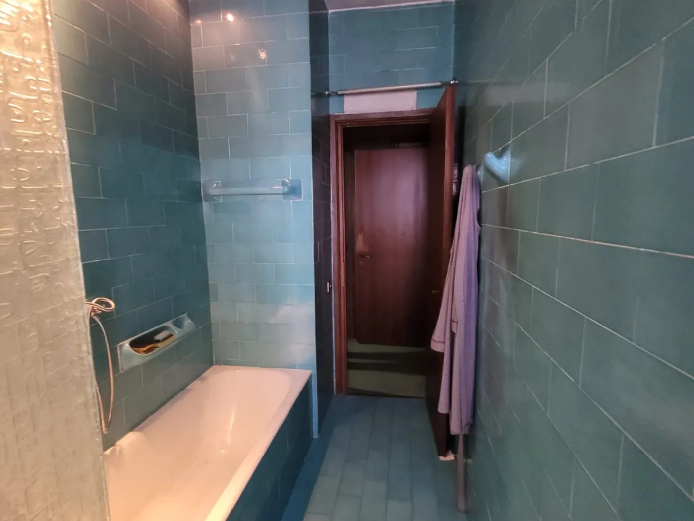 Bilocale open space con cucina grigio antracite e parquet rovere