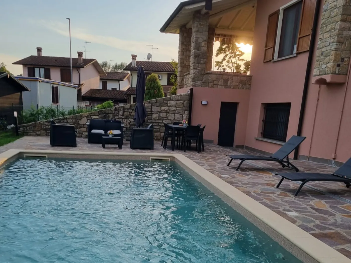 Piscina luxury villa con zona solarium e pavimentazioni design a Cremona